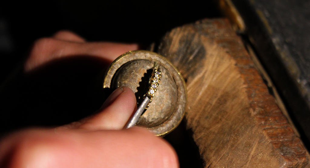 Le mani dell’artigiano incidono un anello d’oro con il bulino